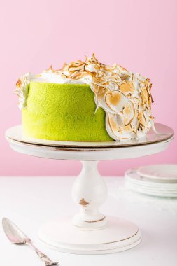 Yeşil kek yanmış kremayla süslenmiş