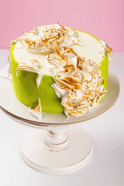 Yeşil kek yanmış kremayla süslenmiş