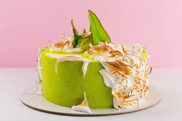 Green cake decorated with burned meringue and colored pear slice — Stock Photo, Image