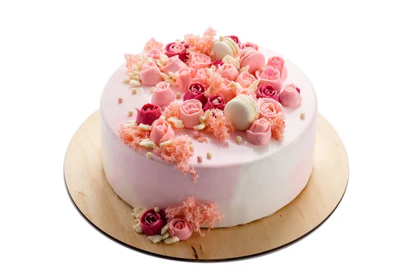 Rosa glasierte Torte mit cremefarbenen Blüten isoliert auf weiß — Stockfoto