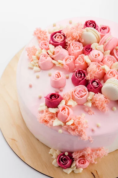 Pink glazed cake with cream flowers on white background — Stock Photo, Image