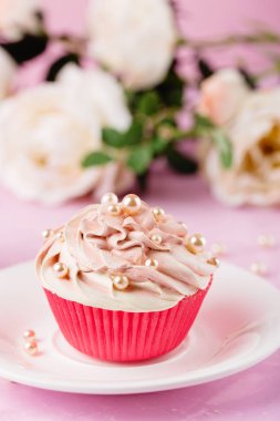 Pembe topkek inci boncuklar ile dekore edilmiştir.