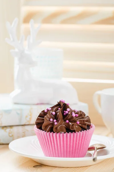 Magdalena de chocolate con espolvoreos en taza rosa — Foto de Stock