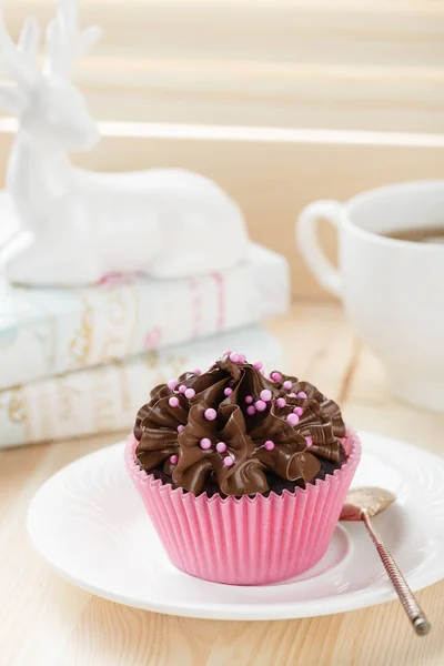 Magdalena de chocolate con espolvoreos en taza rosa — Foto de Stock
