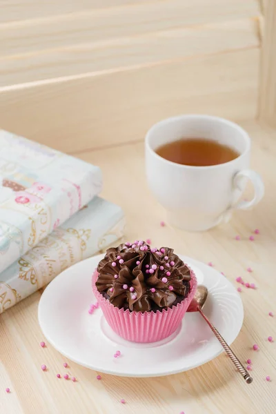 Bolo de chocolate com polvilhas em xícara rosa — Fotografia de Stock