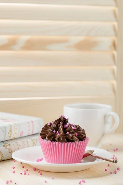 Magdalena de chocolate con espolvoreos en taza rosa —  Fotos de Stock