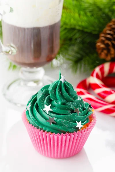 Pastelito de Navidad verde con salpicaduras de estrellas en taza rosa — Foto de Stock