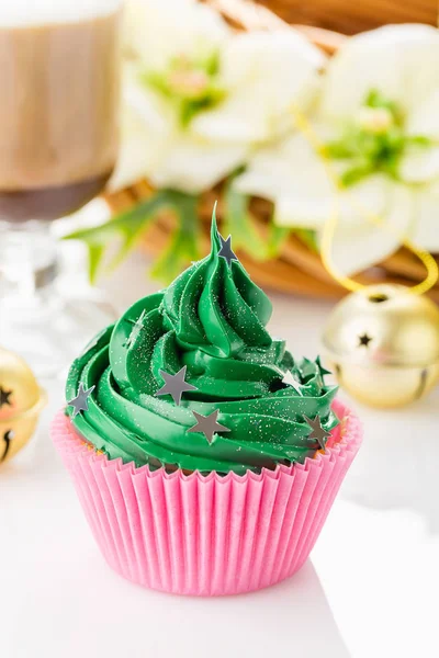 Pastelito de Navidad verde con salpicaduras de estrellas en taza rosa — Foto de Stock