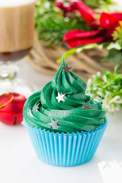 Зеленый рождественский кекс с праздничными украшениями — стоковое фото