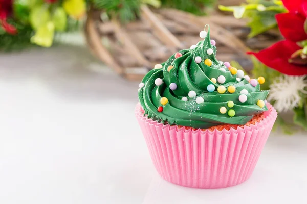 Cupcake di Natale verde con spruzzi colorati in tazza rosa — Foto Stock