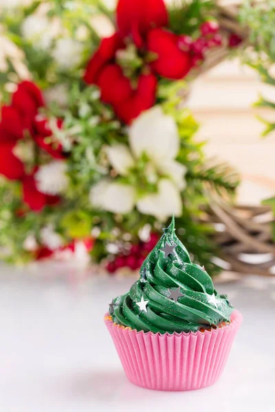 Pastelito de Navidad verde con salpicaduras de estrellas en taza rosa — Foto de Stock