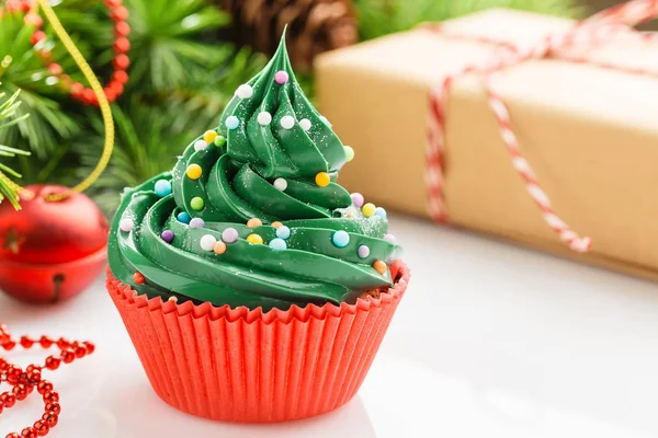 Pastelito verde de Navidad en taza roja con decoraciones — Foto de Stock