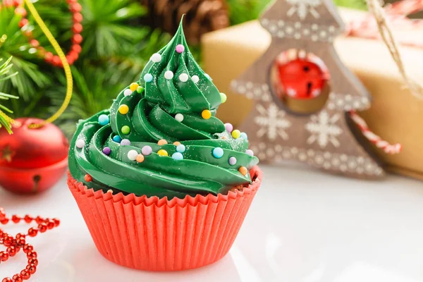 Christmas green cupcake in red cup with decorations — Stock Photo, Image