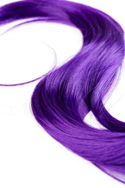 A lock of curly voluminous shiny purple color hair on a white ba — Stock Photo, Image