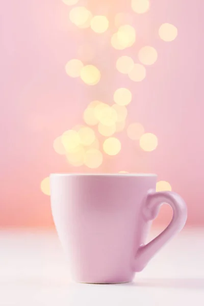 Xícara de café rosa com luzes bokeh — Fotografia de Stock