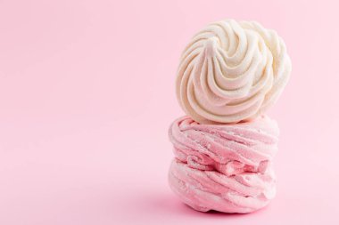 Ev yapımı pembe ve beyaz zephyr veya marshmallow pembe bir arka plan üzerinde