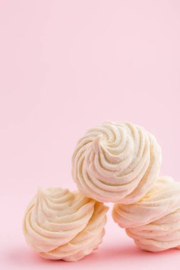 Ev yapımı beyaz zephyr veya marshmallow pembe bir arka plan üzerinde