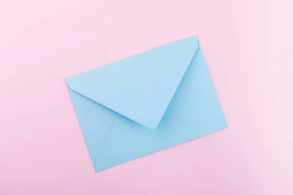 Envelope azul em um fundo rosa — Fotografia de Stock