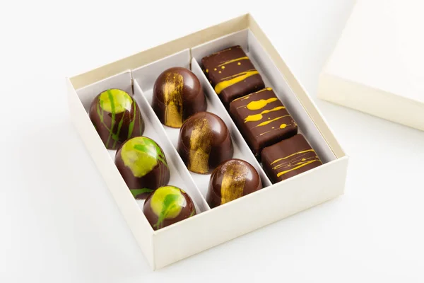 Набор роскошных конфет ручной работы в подарочной коробке на белом фоне — стоковое фото