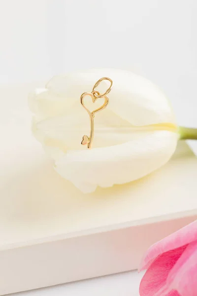 Ciondolo chiave cuore in oro collana su fiore — Foto Stock