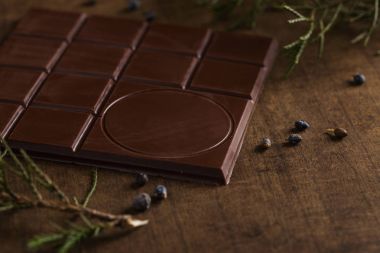 Acı çikolata ile ardıç ahşap arka plan üzerinde