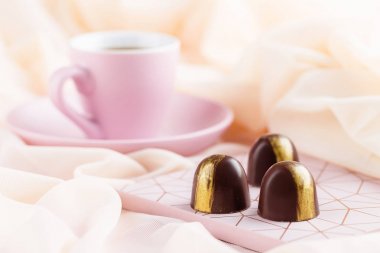 Pastel pembe bir arka plan üzerinde kahve ile lüks bonbon