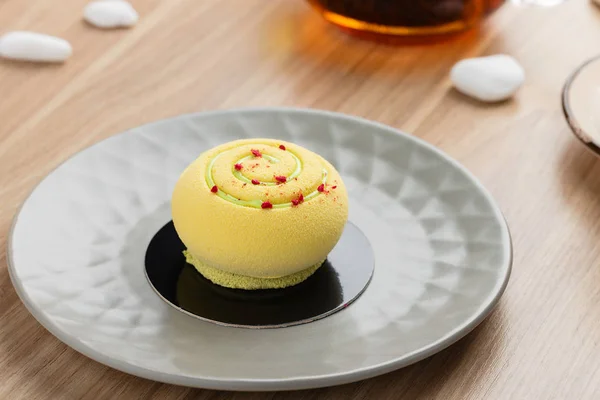 Mini-Moussekuchen bedeckt mit gelbem Schokoladenvelours auf grauem Pl — Stockfoto