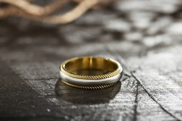 Silver and gold ring on black background