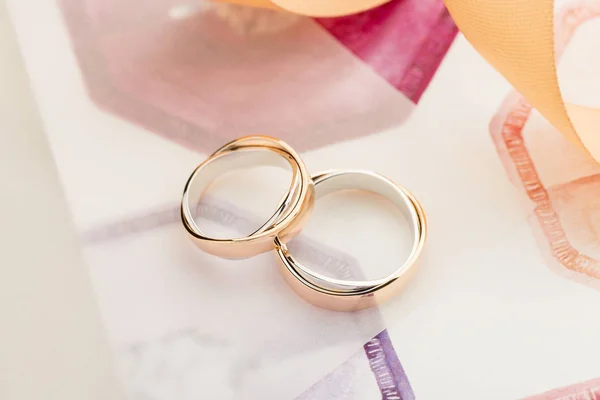 Two white and rose gold wedding rings on pastel background — Stock Photo, Image