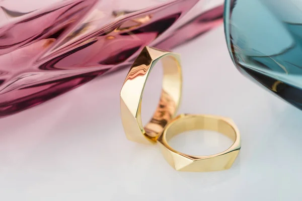 Dos anillos de oro de boda de diseño geométrico sobre fondo blanco con —  Fotos de Stock