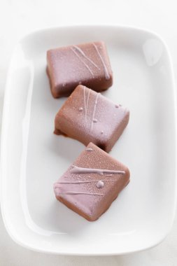 El yapımı sütlü çikolata şeker üzerinde mor sıçraması ile dekore edilmiş olan 