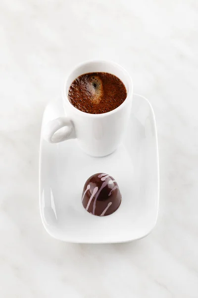 Handgemachte Schokolade mit lila Spritzern auf Teller mit Tasse — Stockfoto