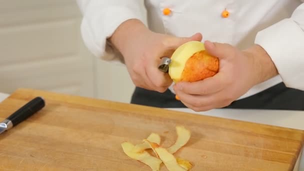 Chef está descascando e cortando uma maçã — Vídeo de Stock