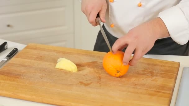 Шеф-кухар очищає і ріже фрукти — стокове відео