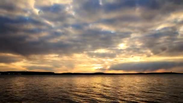 Sonnenuntergang über dem Wasser am Seeufer mit dramatischem bewölkten Himmel — Stockvideo