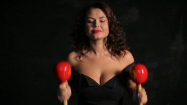 Çekici genç esmer müzisyen kırmızı marakas oynarken