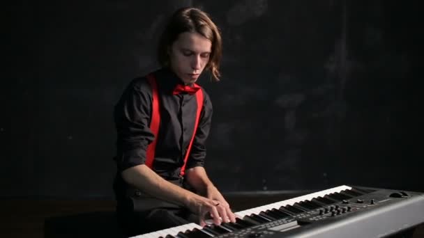 Молодой музыкант играет на пианино — стоковое видео