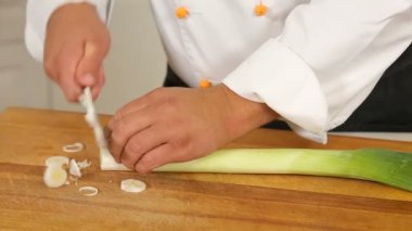 Mutfakta bir kesme tahtası üzerinde bir bıçak ile kesme pırasa