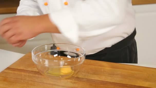 Разбивание и взбивание яиц в стеклянную миску — стоковое видео