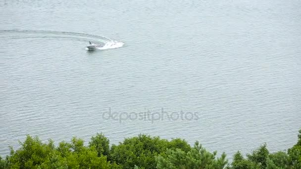 Катание на моторной лодке по берегу озера в летний день — стоковое видео