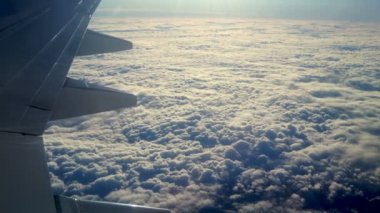 Bulutlar ve gökyüzü bir uçağın penceresinden görüldüğü gibi