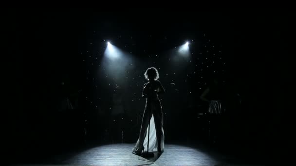 Kadın şarkıcı arkadan aydınlatmalı dumanlı sahnede — Stok video