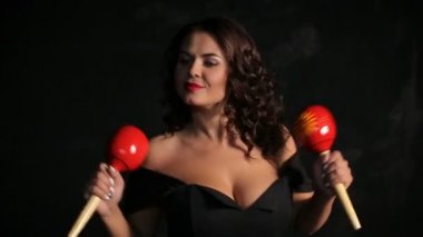 Çekici genç esmer müzisyen kırmızı marakas oynarken