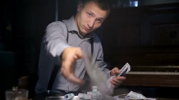 Молодой уверенный гангстер хвастается за игровым столом — стоковое видео