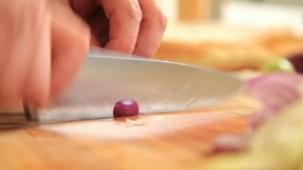Cortar cebollas rojas en una tabla de cortar — Vídeo de stock