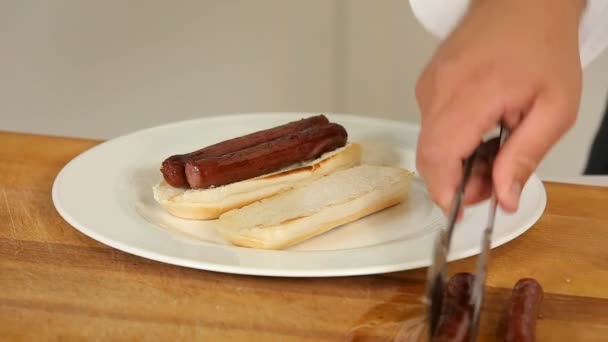 Hacer sándwiches con salchichas a la parrilla y ensalada — Vídeos de Stock