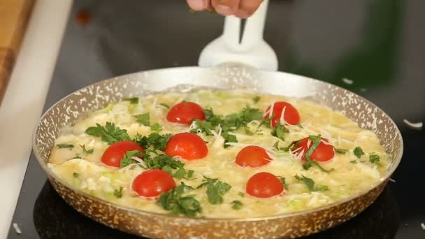 Omelete de ovo de cozinha com tomates cereja em uma panela de ato de fritar — Vídeo de Stock