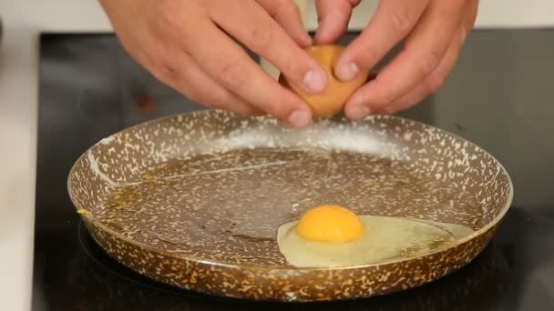 Разбивание и жарка яиц на сковороде — стоковое видео