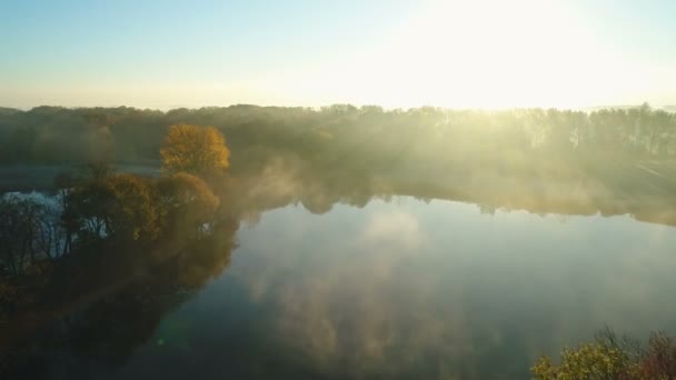 Mlhavý východ slunce nad parkovou uličkou u jezera — Stock video