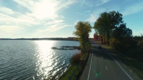 Weg in het herfstbos aan de oever van het meer — Stockvideo